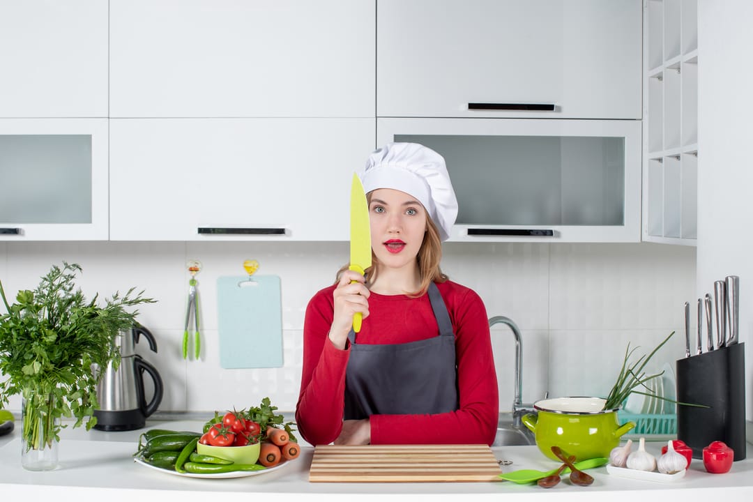 woman chef holding knife in modern kitchen preparing vegetables – Duly Kitchen